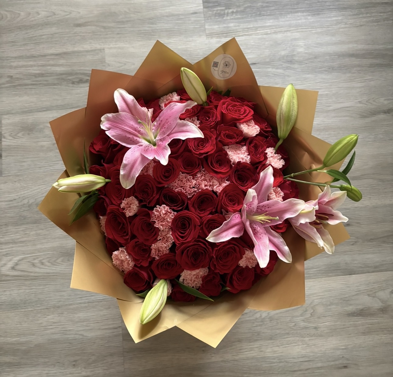 Red rose and pink lily bouquet in gold wrapping
